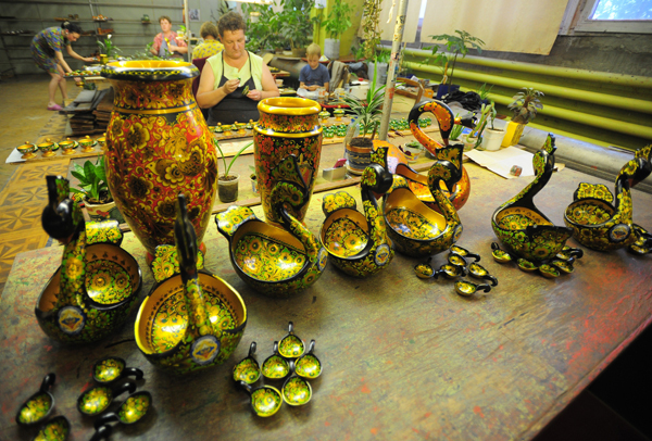  хохломская роспись Изготавливают хохломские изделия из древесины местных лиственных пород - липы, осины, березы. Из просушенного дерева - тонкомерных  стульчиков , распиленных на толстые плахи  кряжей , вытесывают болванки и  чураки . В токарном цехе массивная заготовка превращается в задуманное изделие,  чурак  как бы тает под резцом мастера, все лишнее отлетает с легкой белой лентой стружки.<br />
Фото ИТАР-ТАСС хохломская роспись