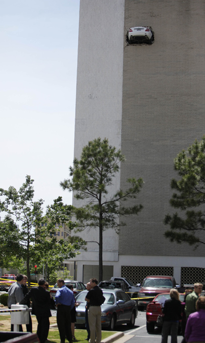 На многоуровневой парковке здания Bank of America в городе Тулса (США, штат Оклахома) произошел неординарный инцидент:  Мерседес  под управлением 67-летнего водителя врезался во внешнюю кирпичную стену на шестом этаже, пробил ее и застрял в проделанной дыре багажником наружу.
Читайте подробнее: Американец перепутал педали и  воткнул  машину в стену